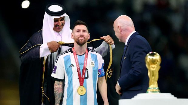 Soccer Football - FIFA World Cup Qatar 2022 - Final - Argentina v France - Lusail Stadium, Lusail, Qatar - December 18, 2022   Argentina's Lionel Messi, Emir of Qatar Sheikh Tamim bin Hamad Al Thani and FIFA president Gianni Infantino during the trophy ceremony REUTERS/Hannah Mckay     TPX IMAGES OF THE DAY