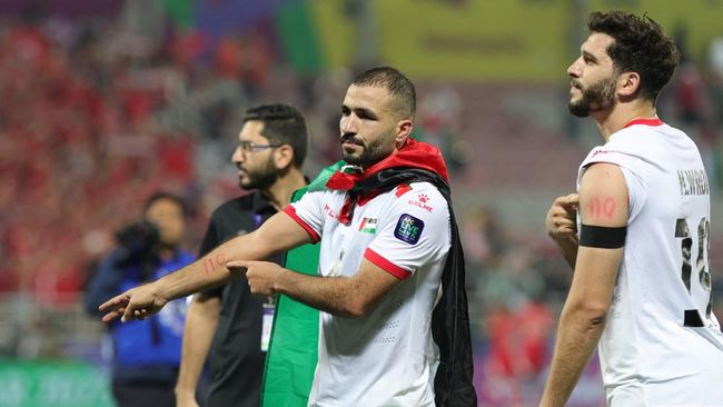 Pemain Palestina Oday Kharoub dan Mahmoud Wadi menunjuk angka 110 di lengan mereka sebagai dukungan kepada warga Gaza usai menang di Piala Asia 2023.